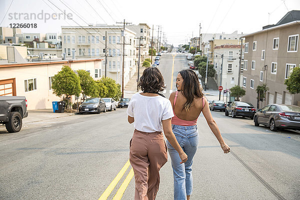 Zwei junge Frauen  die die Straße entlang gehen.