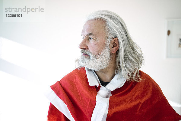 Bärtiger  reifer Mann im Weihnachtsmann-Kostüm  der aussieht wie der Weihnachtsmann