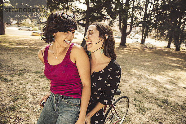 Zwei glückliche junge Frauen auf dem Fahrrad
