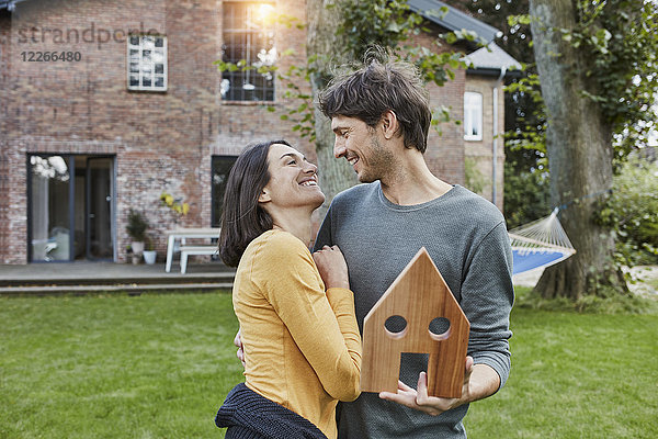Ein glückliches Paar im Garten ihres Hauses als Modell