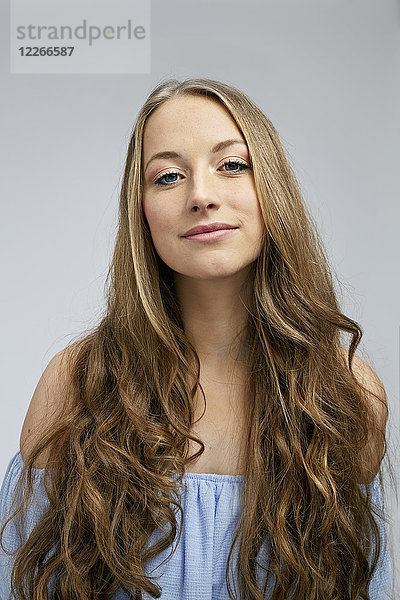 Porträt einer lächelnden jungen Frau mit langen Haaren