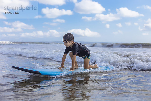 Indonesien  Bali  Junge auf dem Surfbrett