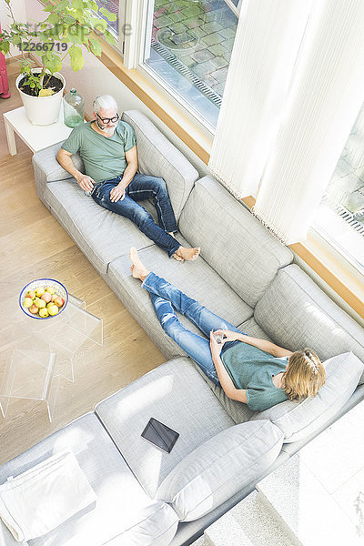 Ein reifes Paar entspannt sich zu Hause auf der Couch.