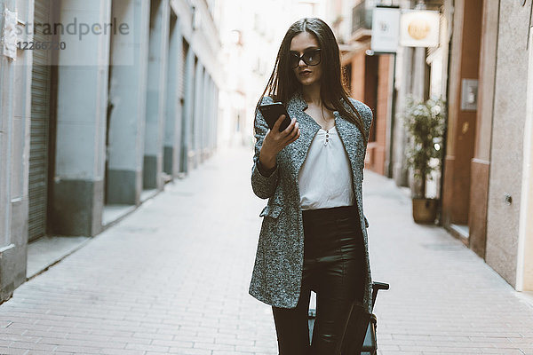 Junge Geschäftsfrau in der Stadt überprüft Handy