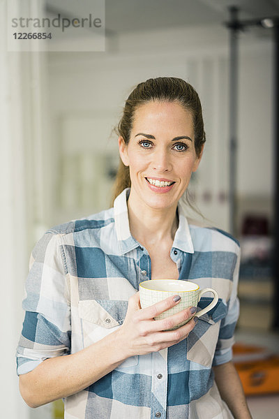 Porträt einer schönen Frau  die zu Hause Kaffee trinkt
