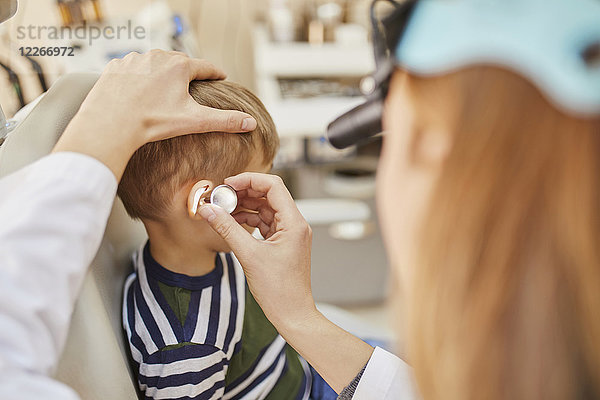 HNO-Arzt untersucht Ohr eines Jungen