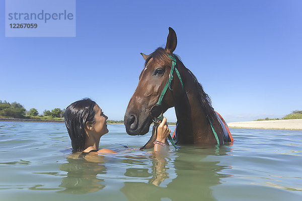 Indonesien  Bali  Frau mit Pferd im Wasser