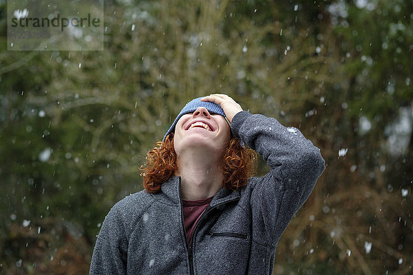 Fröhlicher Teenager genießt Schneefall