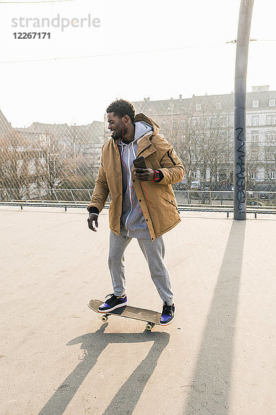 Junger Mann auf dem Skateboard auf dem Platz