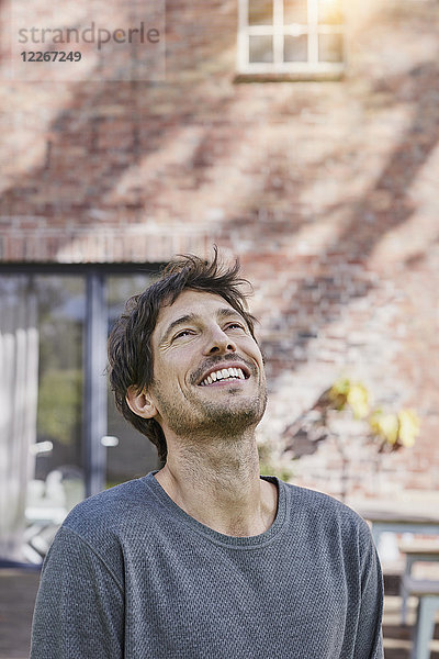 Porträt eines glücklichen Mannes vor seinem Haus