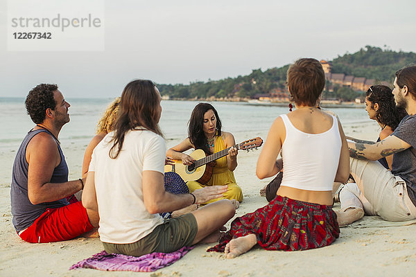 Thailand  Koh Phangan  Gruppe von Menschen am Strand mit Gitarre
