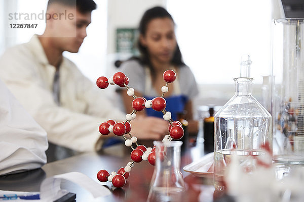 Molekülstruktur auf dem Tisch gegen junge Studenten im Chemielabor