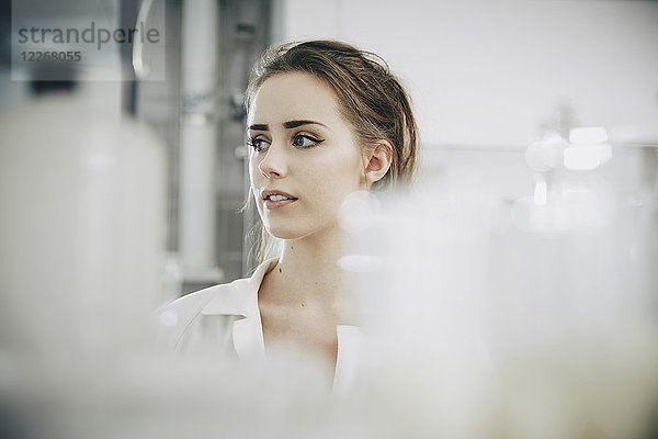 Selbstbewusste junge Studentin schaut weg  während sie im Labor steht.