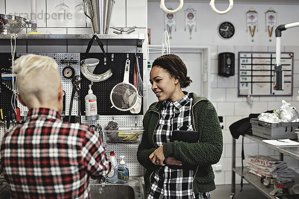 Arbeiterinnen diskutieren bei der Arbeit in der Brauerei