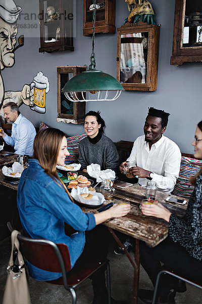 Großer Blickwinkel auf multiethnische Freunde beim Brunch im Restaurant