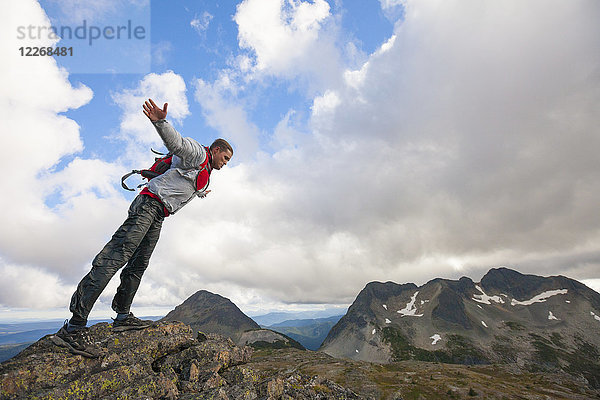 Wanderer lehnt sich bei starkem Wind auf einem felsigen Bergkamm über  Merritt  British Columbia  Kanada