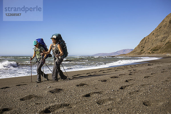 Zwei Wanderinnen wandern Seite an Seite am Strand der Lost Coast  Kalifornien  USA