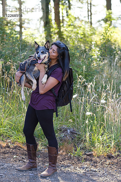 Frau hält ihren Hund während einer Wanderung in Oregon  USA  hoch