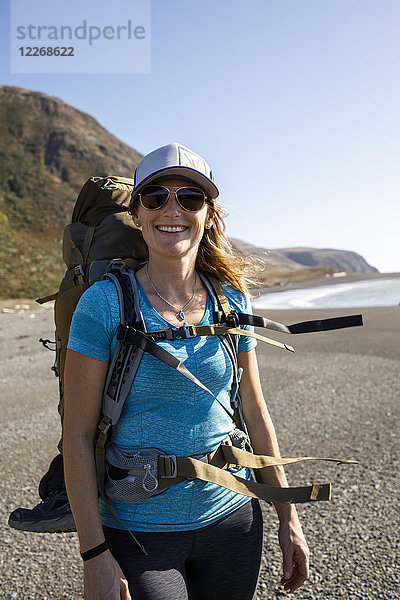 Porträt einer Wanderin  die am Strand der Lost Coast steht und in die Kamera lächelt  Kalifornien  USA