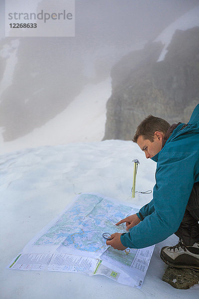Bergsteiger  der mit Karte und Kompass navigiert  nachdem sich das Wetter verschlechtert hat  British Columbia  Kanada