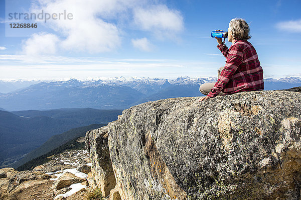 Wanderin  die sich ausruht und Wasser trinkt  auf dem Gipfel des Whistler Mountain  Garibaldi Provincial Park  Whistler British Columbia  Kanada