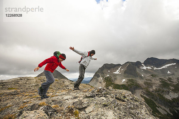 Zwei Wanderer kämpfen gegen den starken Wind auf einem felsigen Bergrücken  Merritt  British Columbia  Kanada