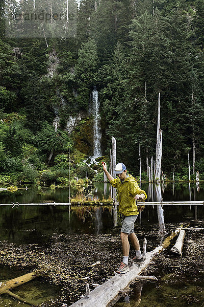 Wanderer balanciert auf einem umgestürzten Baum über einem See  Washington  USA