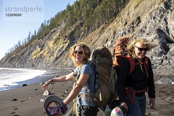 Rucksacktouristinnen lächelnd beim Wandern am Strand  Lost Coast Trail  Kings Range National Conservation Area  Kalifornien  USA