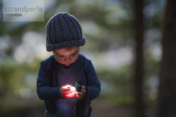 Junge mit Stirnlampe im Wald am Abend  Harrison Hot Springs  British Columbia  Kanada