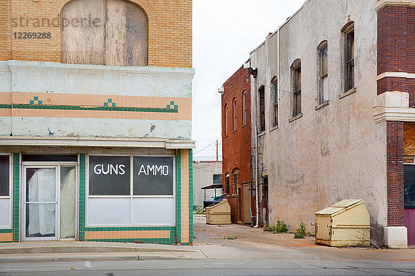 Fassade eines verlassenen Gebäudes an einer Straßenecke  Waffen- und Munitionsgeschäft.