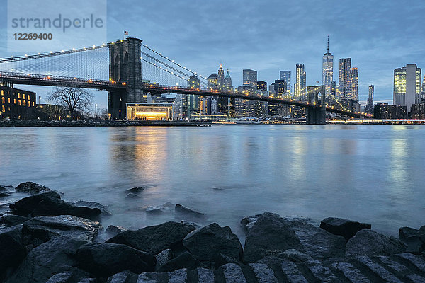 Stadtbild mit Brooklyn Bridge und der Skyline von Lower Manhattan in der Abenddämmerung  New York  USA