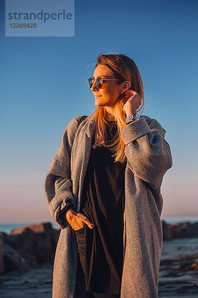 Porträt einer Frau mit Sonnenbrille und Wintermantel beim Wegschauen  Odessa  Odeska Oblast  Ukraine  Osteuropa