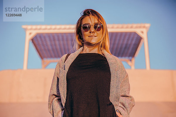 Porträt einer Frau mit Sonnenbrille  die lächelnd in die Kamera schaut