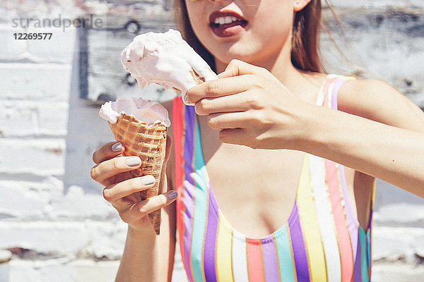 Junge Frau hält zwei schmelzende Eistüten in der Hand  abgeschnitten