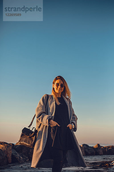 Porträt einer Frau mit Sonnenbrille und Wintermantel  die lächelnd in die Kamera schaut  Odessa  Odeska Oblast  Ukraine  Osteuropa