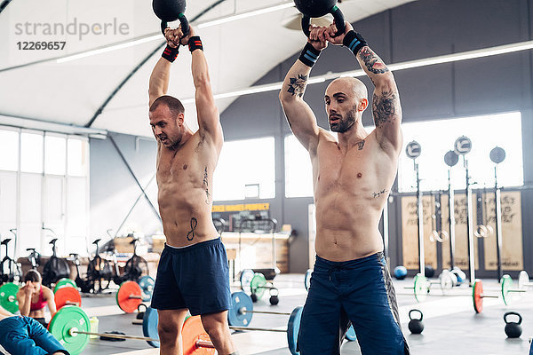 Gewichtheben von Männern mit Kesselglocken im Fitnessstudio