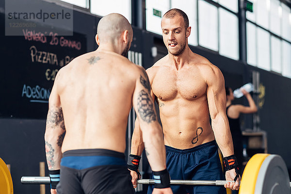 Gewichtheben von Männern mit Langhantel im Fitnessstudio
