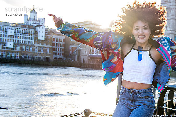 Porträt einer jungen Frau im Freien  die vor Freude springt  London  England  UK