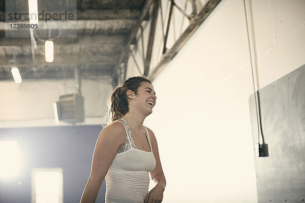 Porträt einer Frau im Fitnessstudio  die lächelnd wegschaut