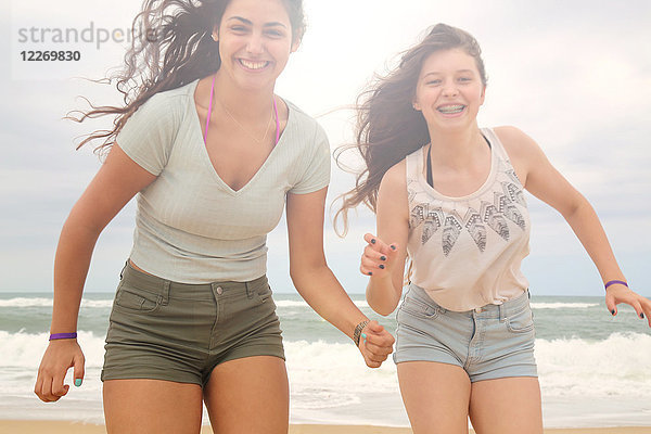 Porträt von zwei Teenager-Mädchen am Strand  lächelnd