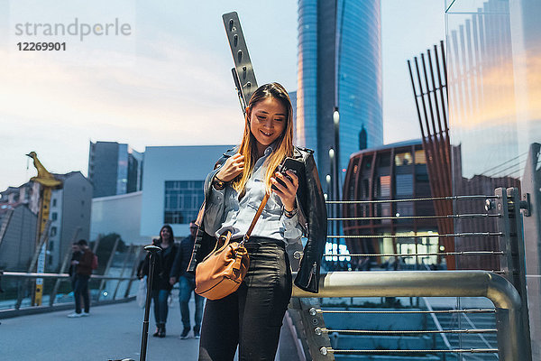 Frau im Freien  mit Smartphone  bei Videoanrufen  lächelnd