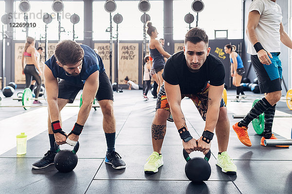Gewichtheben von Männern mit Kesselglocken im Fitnessstudio