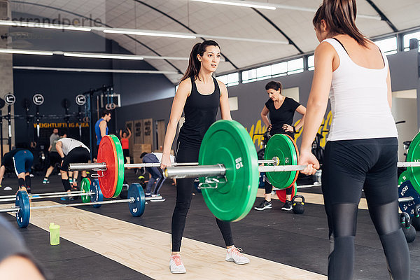Frauen beim Gewichtheben mit Hanteln im Fitnessstudio