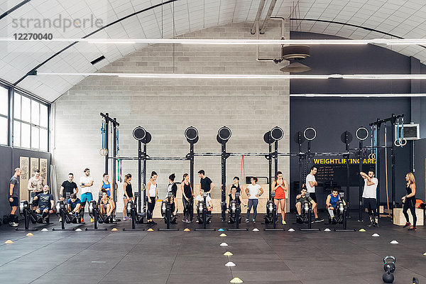 Große Gruppe von Menschen trainiert im Fitnessstudio