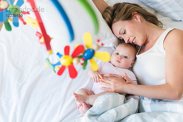 Mutter und Baby im Bett  Blick auf Krippenkarussell