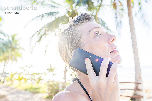 Frau am Strand  mit Smartphone  Nahaufnahme  Nacpan Beach  Palawan  Philippinen