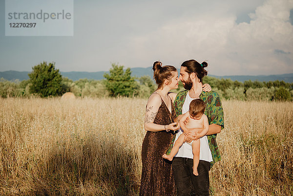 Paar mit Mädchen auf goldenem Grasfeld  Arezzo  Toskana  Italien