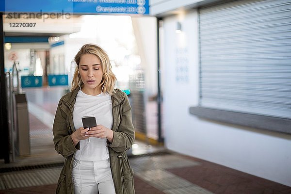 Frau benutzt Mobiltelefon an der Fahrkartenabsperrung  Kapstadt  Südafrika