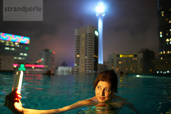 Tourist beim Selbstbedienungsbad auf dem Dach  KL Tower im Hintergrund  Kuala Lumpur  Malaysia