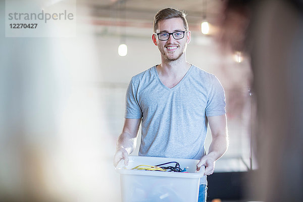 Computertechniker mit Kabelkasten im Büro  Portrait